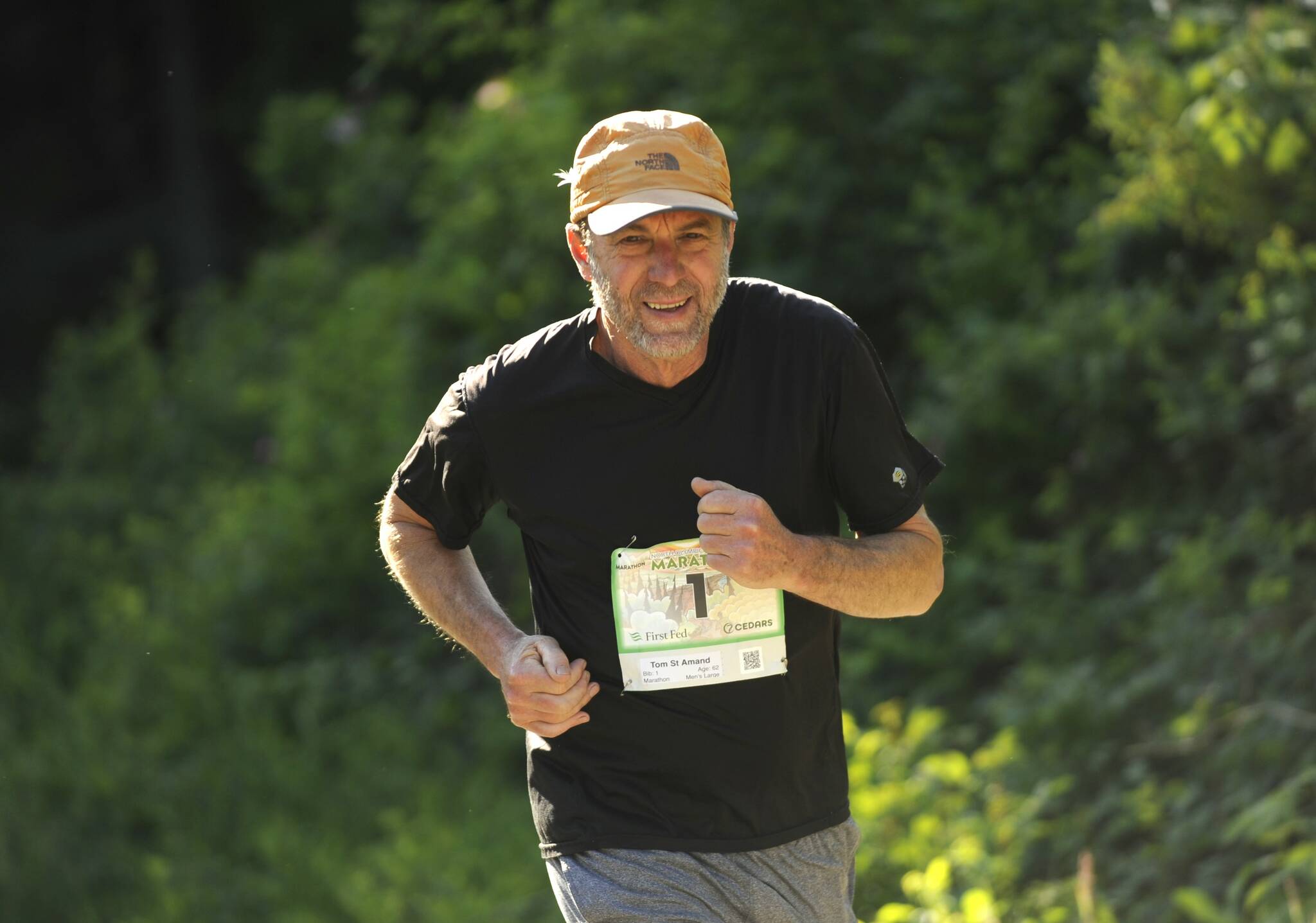 Sequim Gazette photo by Michael Dashiell / Tom St. Amand of Port Angeles grins as he makes his way up a hill at Whitefeather Way during the June 4 North Olympic Discovery Marathon.