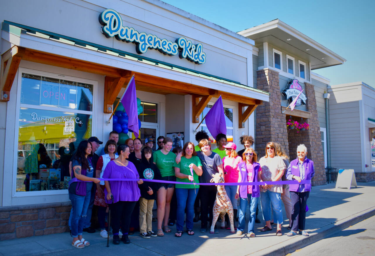 Photo by Monica Berkseth / Community members and the Sequim-Dungeness Valley Chamber of Commerce helps Dungeness Kids Co. owner Susan Baritelle, center, celebrate the business’ 15th anniversary on July 15 with a ribbon-cutting ceremony. The store is at 163 W. Washington St. See dungenesskids.com.