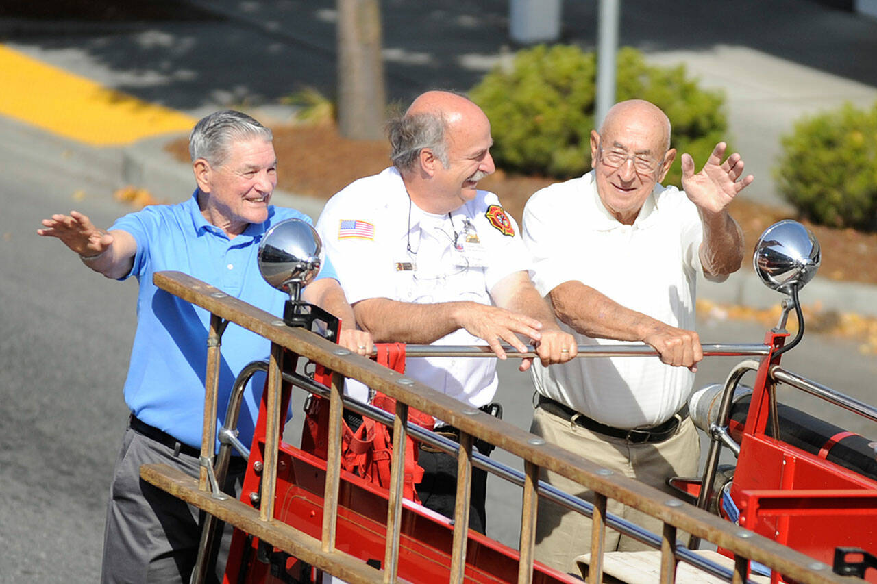 Sequim Gazette file photo by Michael Dashiell
Former Clallam County Fire District 3 fire chiefs, from left, Tom Lowe, Steve Vogel, and former fire commissioner Lawrence Kettel ride in the fire district’s Centennial Celebration parade in 2014. The fire department seeks a new fire chief after Ben Andrews moved to remote work with plans to retire in 2024.
