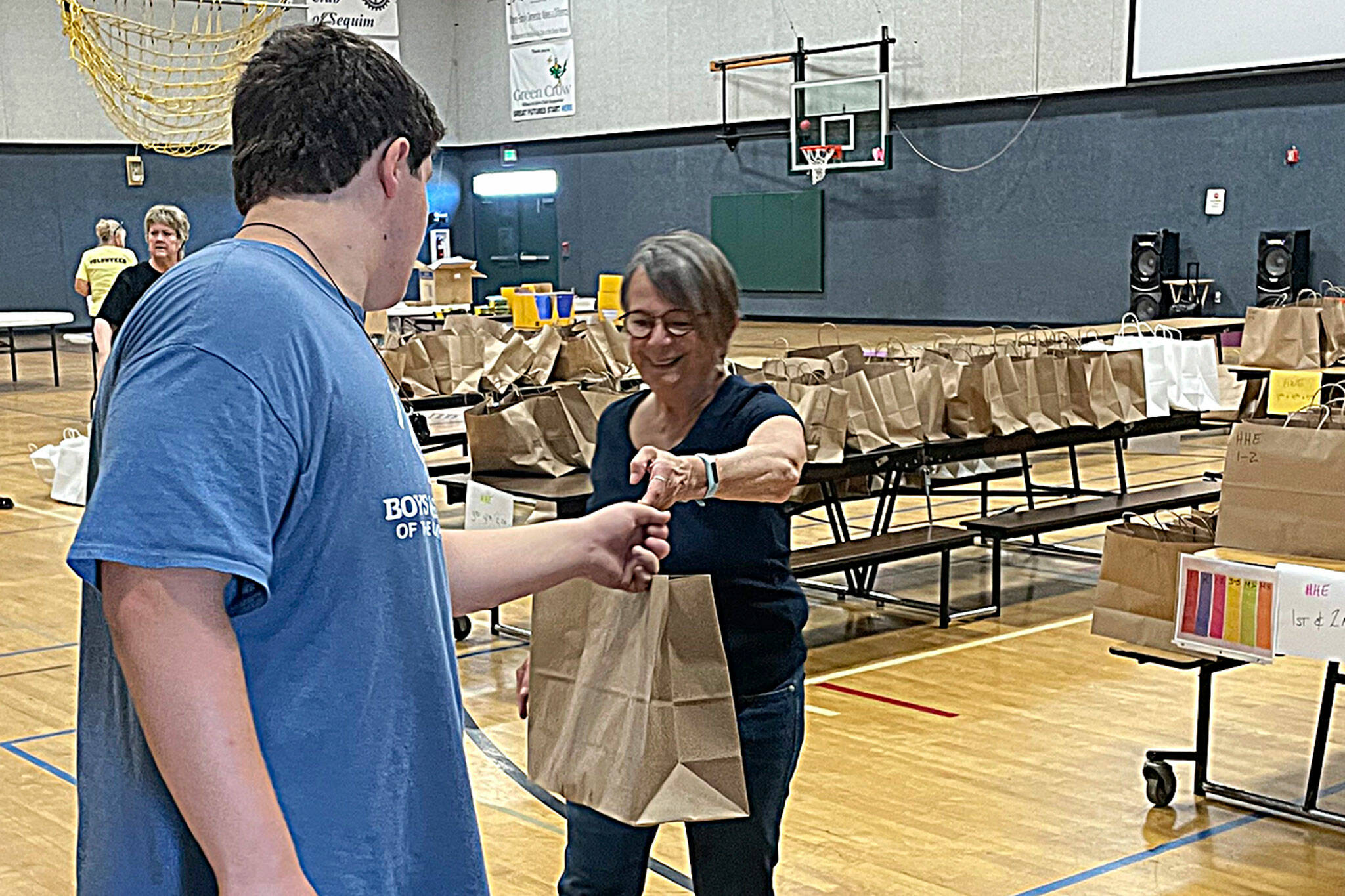 Sequim Gazette photo file by Matthew Nash
Amala Kuster with the Sequim Sunrise Rotary hands off a bag to James Joseph Dorrell, 14, with the Boys & Girls Club, during the Back to School Fair in 2022.