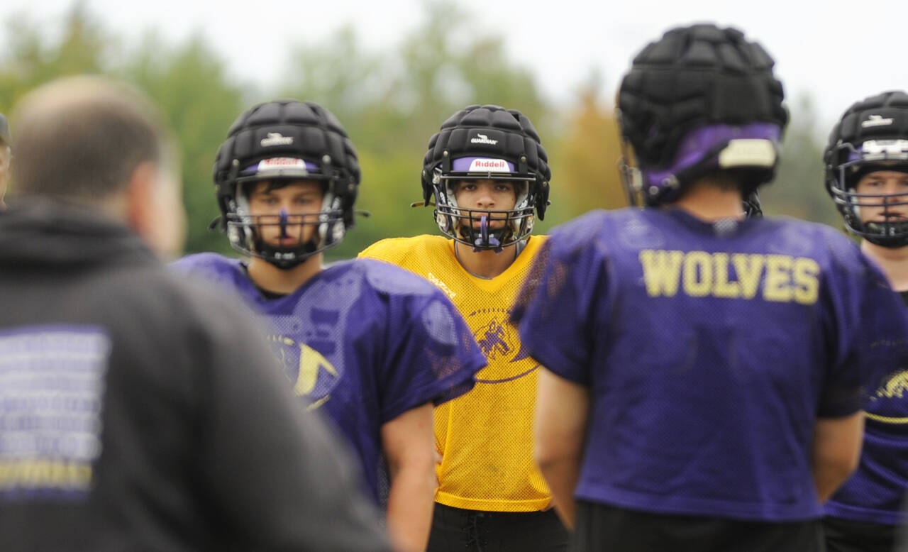 Sequim Gazette photo by Michael Dashiell / Sequim quarterback Lars Wiker, center, and the Wolves listen in on instructions from head coach Erik Wiker in a preseason practice last week.
Sequim Gazette photo by Michael Dashiell / Sequim quarterback Lars Wiker, center, and the Wolves listen in on instructions from head coach Erik Wiker in a preseason practice last week.
