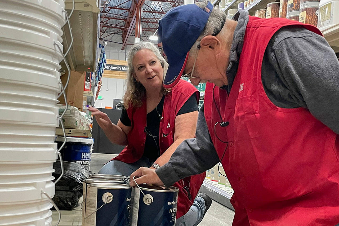 Sequim Gazette photo by Matthew Nash/ Jacqueline Lee, supervisor, and Bob Wasserman, a sales associate, stock paint inside Ace Hardware as they prepare for the Aug. 31 grand opening in the Sequim area.