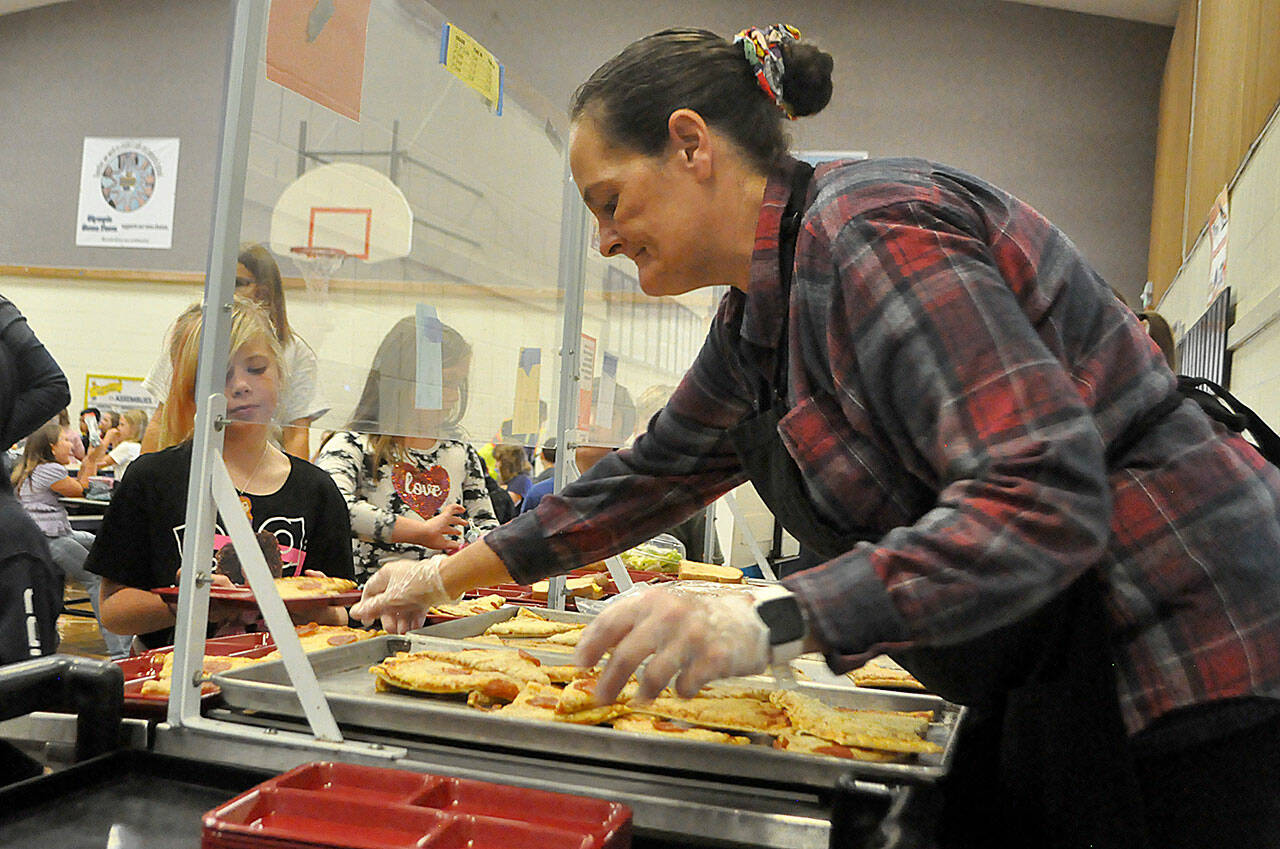 Sequim Gazette photo by Matthew Nash
Heather Conklin, a food service worker at Helen Haller Elementary, serves pizza to students on Sept. 8 during lunch. All Sequim School District students are eligible for free meals during school days under two programs that the district qualified.