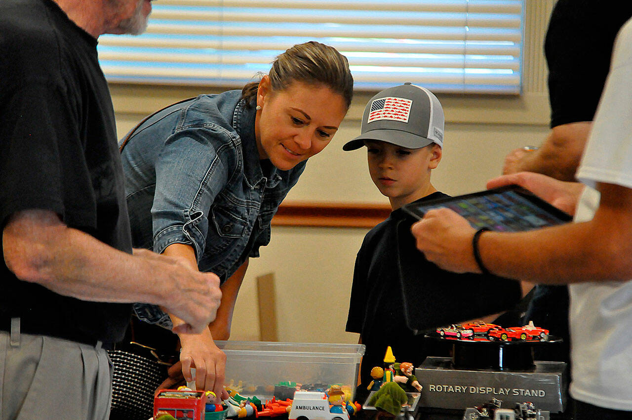 Sequim Gazette photo by Matthew Nash
Mother-and-son Stephanie and eight-year-old Kosta Stamoolis look at a booth on Sept. 9 at the Olympic Peninsula Toy and Collectibles Show. Stephanie said her son loves toy cars so they were going to look around and find one toy to take home. Cartoon characters, Hot Wheels, monsters, superheroes, and more made appearances at the inaugural Olympic Peninsula Toy and Collectibles Show on Saturday. The event filled the Guy Cole Events Center in Carrie Blake Community Park with local and out-of-area vendors selling a variety of new and vintage toys. Organizer Corey Edwards said the venue “worked beautifully, it was a gorgeous day, and spirits seemed to be riding high. I received many positive comments from shoppers and vendors throughout the day.” Vendors all had fun, Edwards said, and they would like to do it again with details in the works about a possible show in spring 2024. For more information, visit peninsulatoyshow.com or facebook.com/groups/peninsulatoyshow.