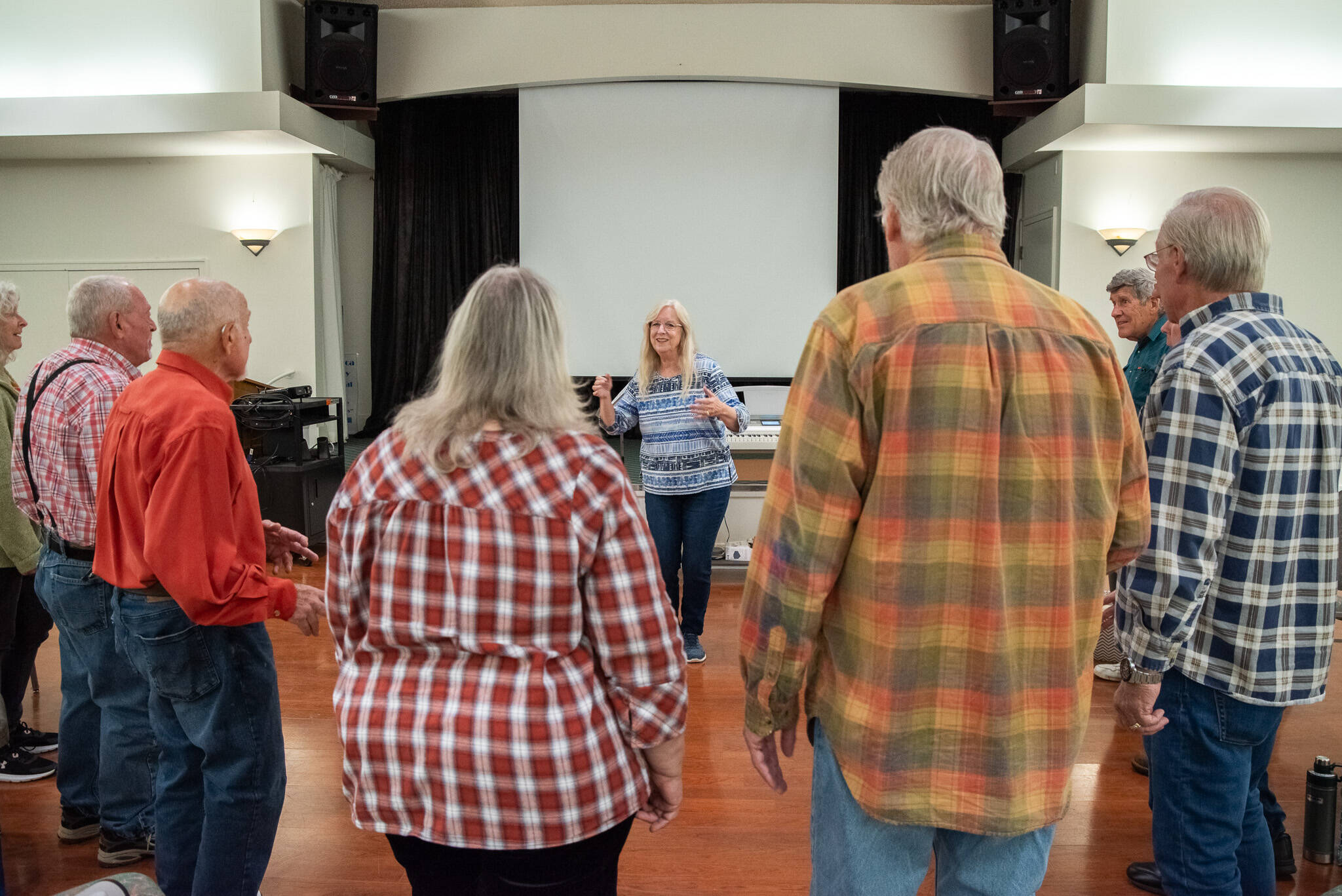 Sequim Gazette photo by Emily Matthiessen / Director Linda Muldowney leads the Juan de Fuca Harmony chorus in song as they prepare for their 40th anniversary concert. Muldowney has been directing the chorus since 2018.