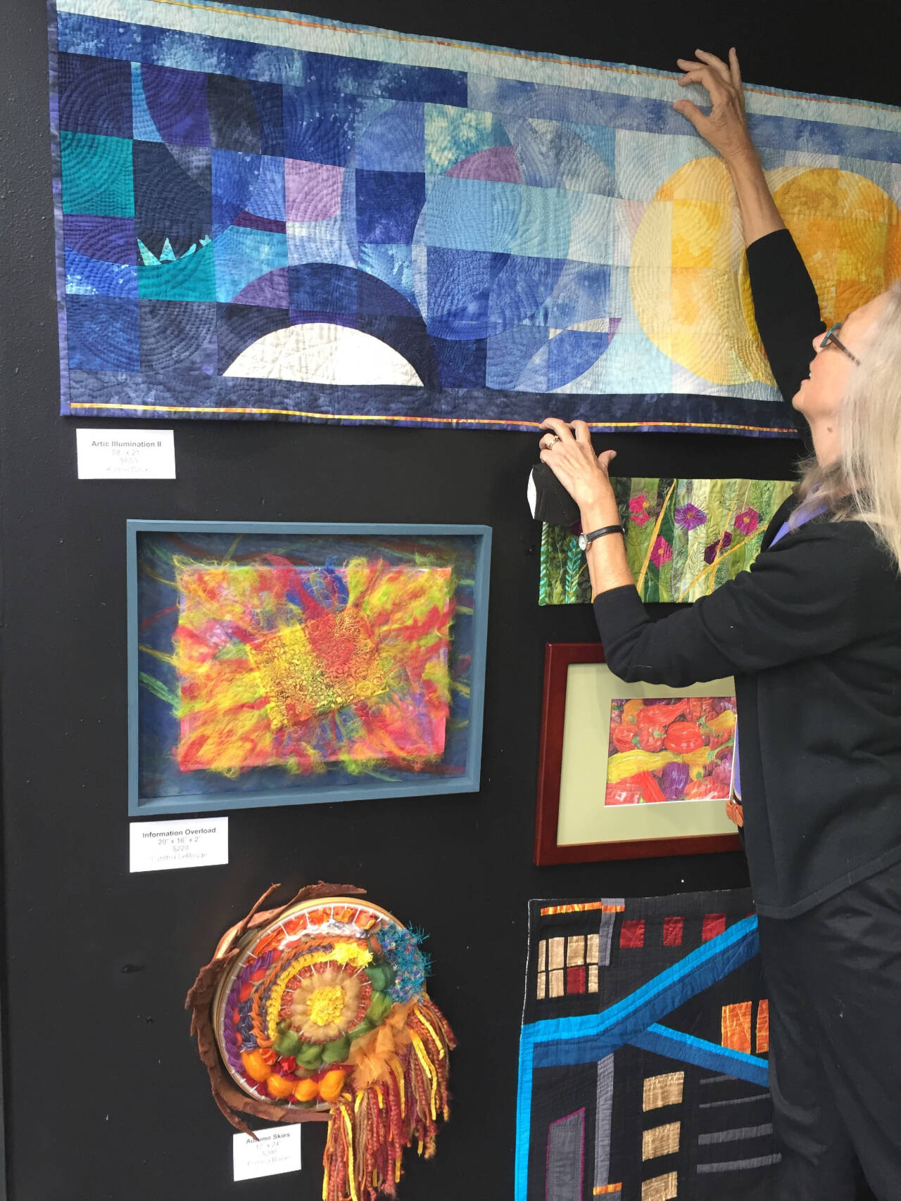 Photo courtesy of Kathie Cook /  Sequim artist Kathie Cook hangs her art quilt, “Arctic Illumination,” in the new Peninsula Fiber Artists exhibit at 675 Tyler St. in uptown Port Townsend.