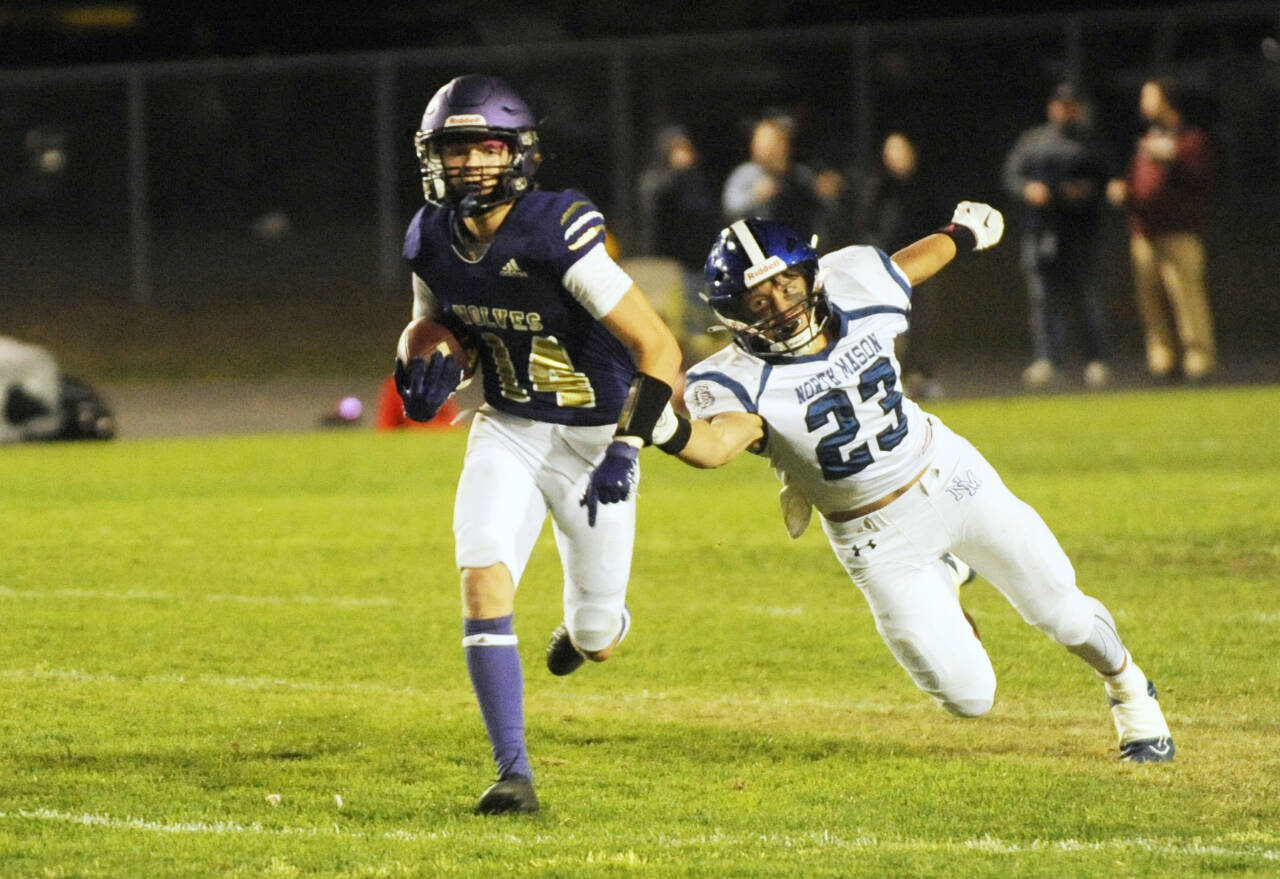 Sequim Gazette photo by Michael Dashiell
Sequim’s Zeke Schmadeke, left, races away from North Mason defender Caden Atencio in the Wolves’ 36-0 Homecoming victory on Oct. 13.