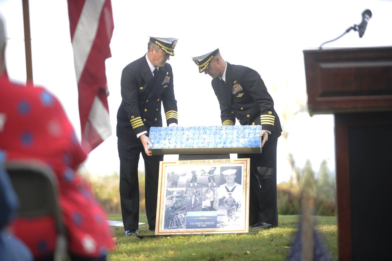 Sequim Gazette photo by Michael Dashiell / Capt. Brent Paul, left, and Capt. Benjamin Leppard of Naval Facilities Engineering Systems Command Northwest lead the annual Veterans Day Remembrance Program at Gardiner Community Cemetery, in honor of Medal of Honor recipient construction mechanic third class Marvin G. Shields, on Nov. 11. Shields is the only Navy Seabee to have received the Medal of Honor. He was posthumously awarded the Medal of Honor for heroism above and beyond the call of duty in the Vietnam War. A native of Gardiner, Shields was buried with a Marine Corps honor guard at the Gardiner Cemetery on June 19, 1965.