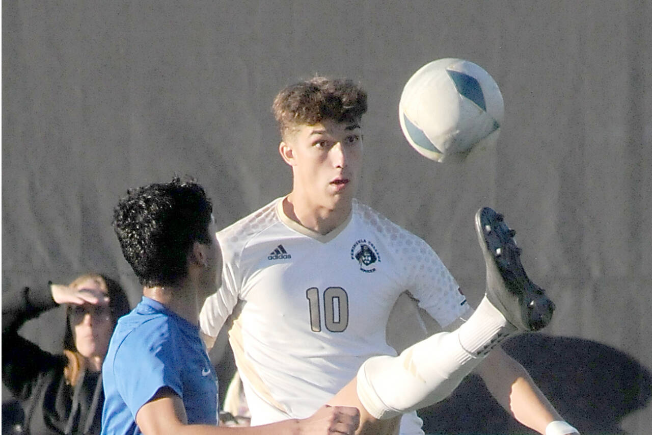 Photo by Keith Thorpe/Olympic Peninsula News Group
Peninsula’s Nil Grau gives a high kick to keep the ball out of reach of Edmond’s Enzo Buenaventura during a match at Wally Sigmar Field in October. Grau was recently named NWAC North Region’s Most Valuable Player.