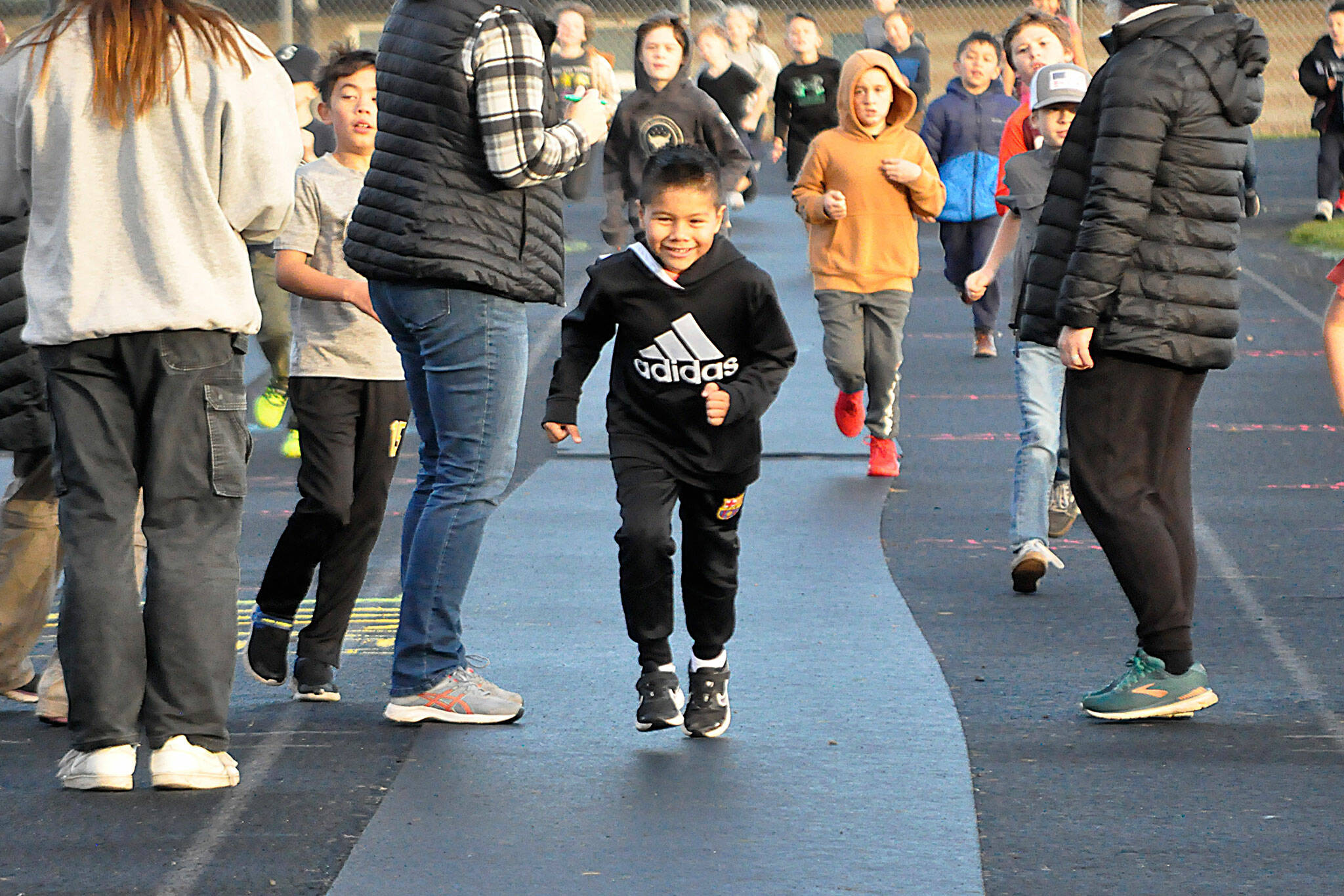 At left: Second-grader Edison Gallegos races ahead during the Turkey Trot on Nov. 22 on the Sequim School District track.