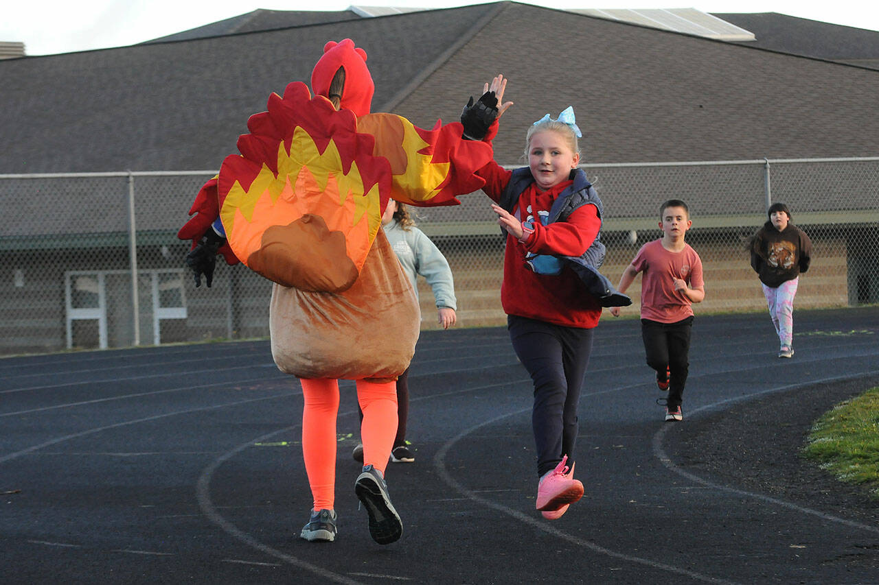 Sequim Gazette photo by Matthew Nash
Third-grader Jasmine Glass high fives principal Becky Stanton during the Turkey Trot on Nov. 22. Both Greywolf and Helen Haller Elementary schools held the events where students did laps to raise funds for books and special programs at their school.
