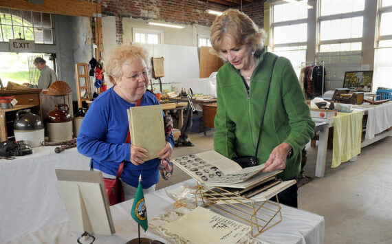 Maureen Sandison, left, and Valle Nevaril, both of Port Angeles, examine high school year books on sale at the North Olympic History Center's Vintage Sale on Saturday at the former Lincoln School in Port Angeles. The sale, which included collectables, vintage clothing, tools and other items, was designed to benefit the center's programs and operations. (Keith Thorpe/Peninsula Daily News)