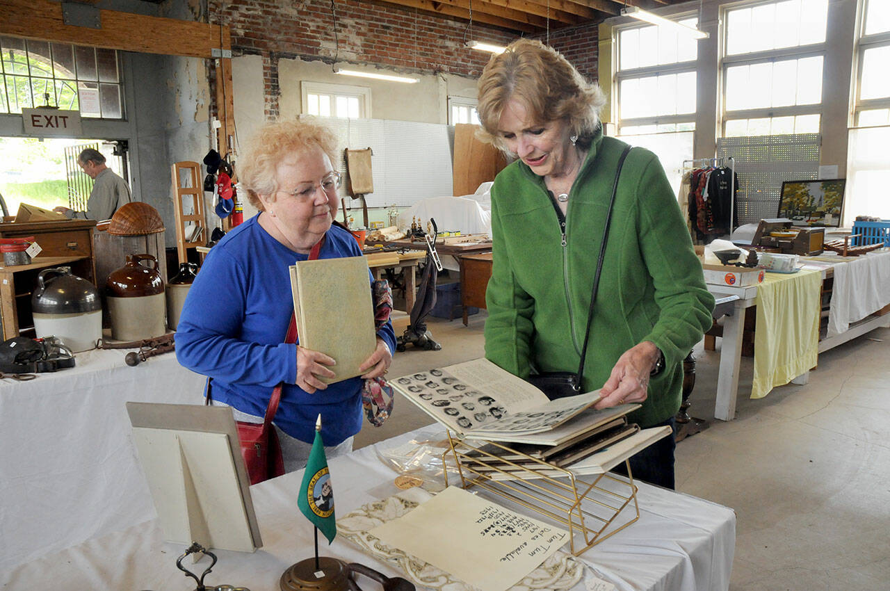 Maureen Sandison, left, and Valle Nevaril, both of Port Angeles, examine high school year books on sale at the North Olympic History Center’s Vintage Sale at the former Lincoln School in Port Angeles in May.