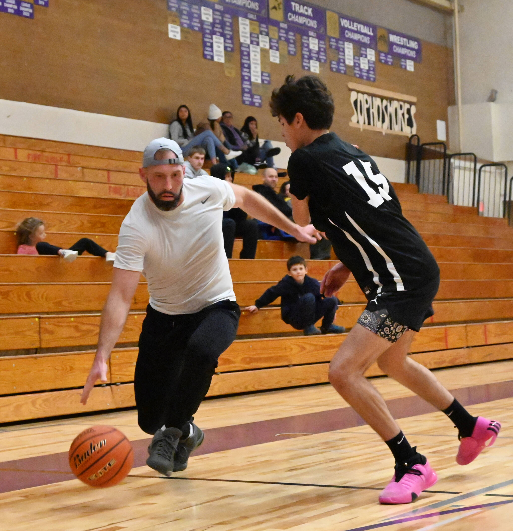 Ian Austin, left, looks to dribble past Vince Carrizosa in Sequim High School’s annual alumni game on Nov. 24.