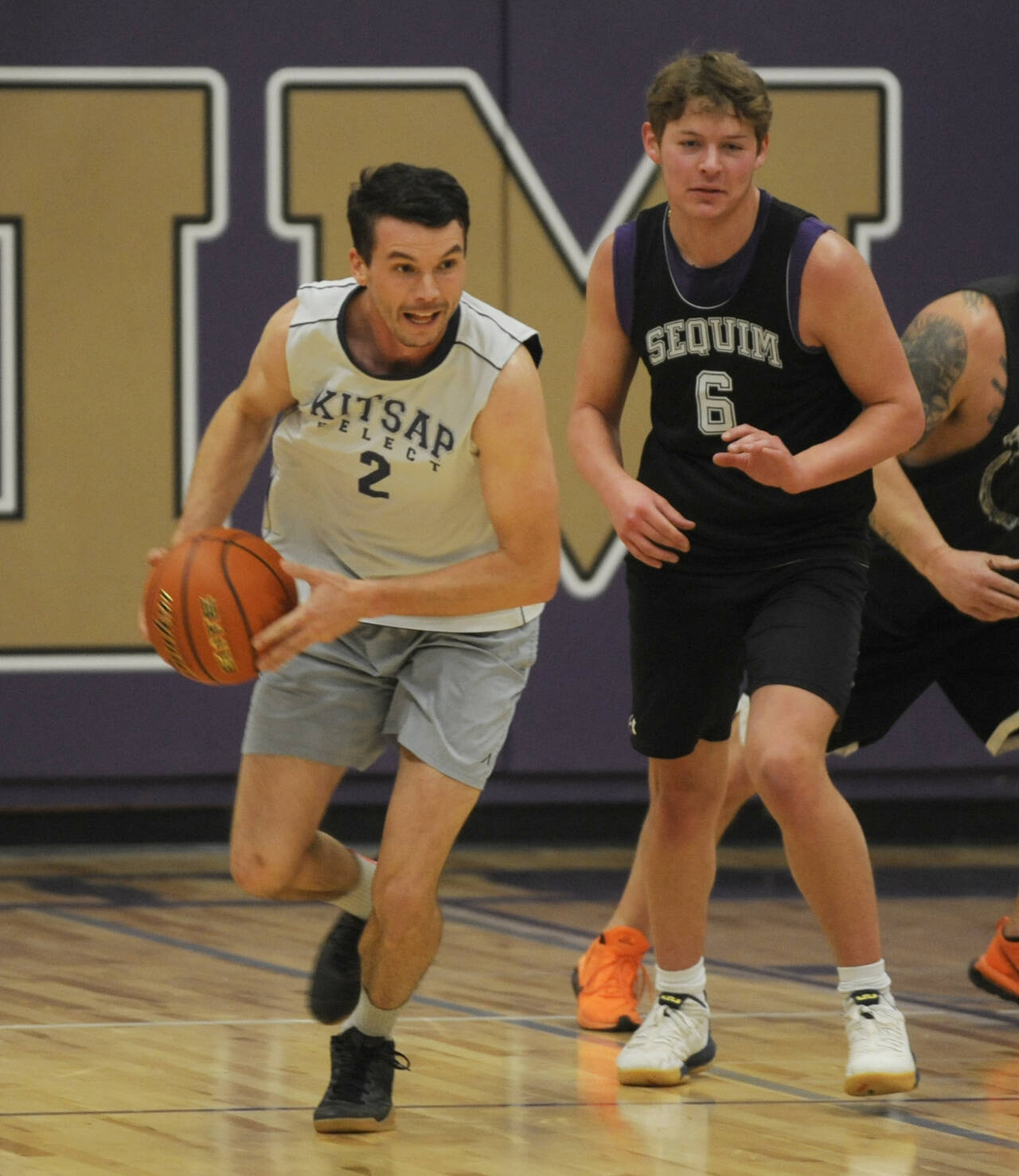 Sequim Gazette photo by Michael Dashiell / Sequim High alum Jayson Brocklesby, left, and Zack Thompson push the ball upcourt in the Nov. 24 alumni game at Rick Kaps Gymnasium.