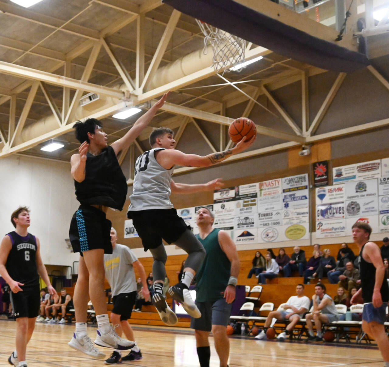 Sequim Gazette photo by Michael Dashiell / Sequim High alum John Textor drives to the basket for a score in the school’s annual alumni game on Nov. 24.