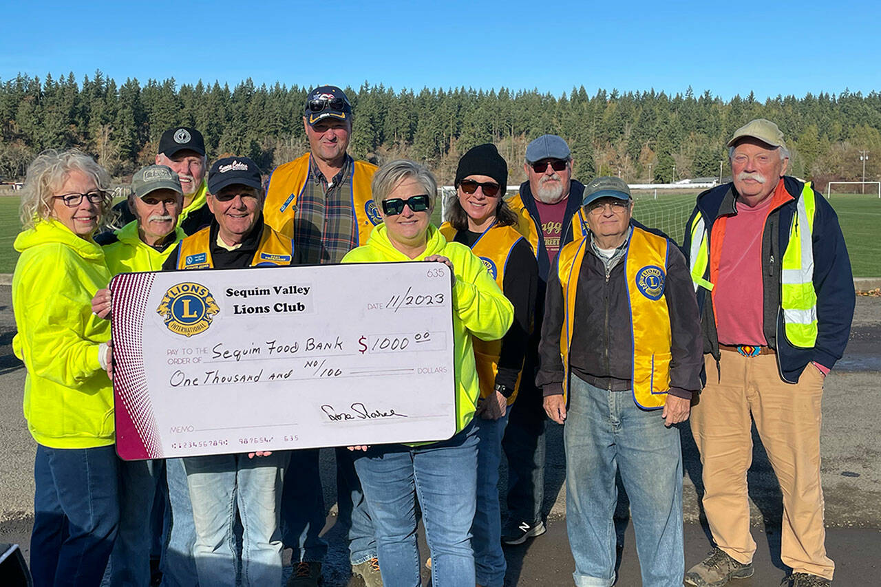 Sequim Gazette photo by Matthew Nash
Sequim Valley Lions Club members donate $1,000 to the Sequim Food Bank to help the non-profit with its Family Holiday Meal Bag program.