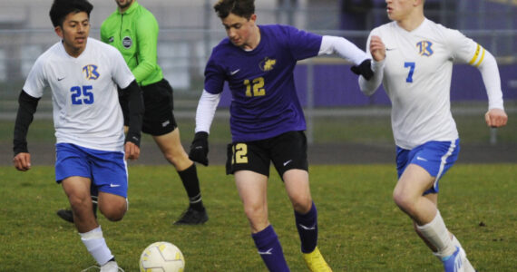 Sequim Gazette photo by Michael Dashiell / Sequim’s Joshua Alcaraz, center, advances the ball in the first half of a March 30 match-up against Bremerton, as Knights Johnny Gaspar Raymundo, left, and Brennan Galloway pursue the play.