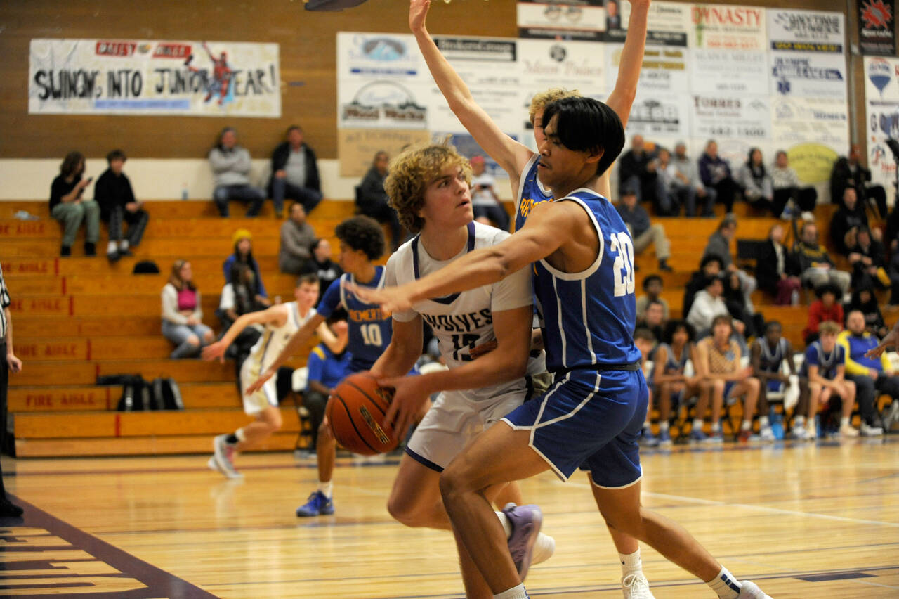 Sequim sophomore Zeke Schmadeke looks to pass from a Bremerton trap along the baseline on Dec. 12.