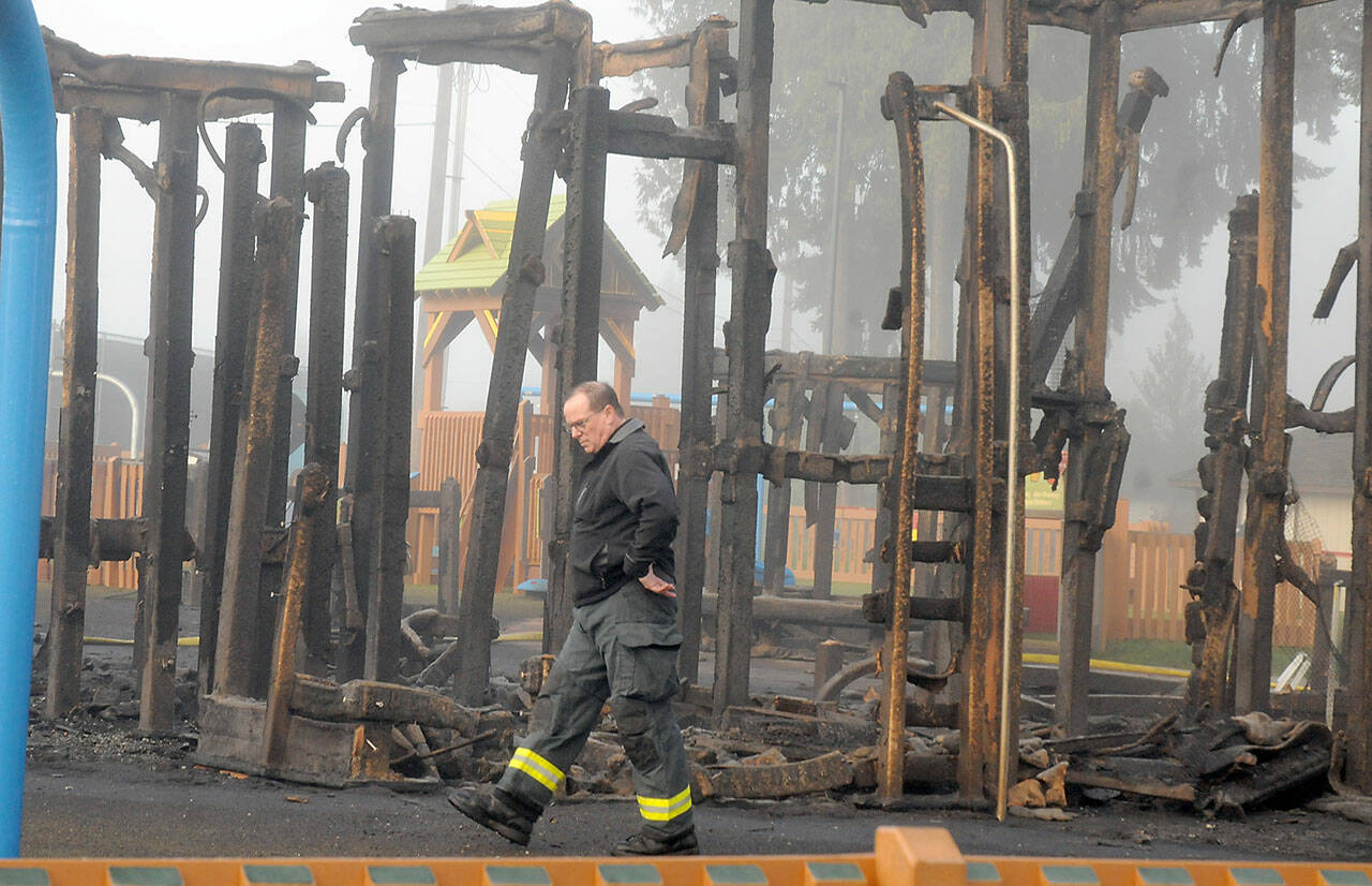 Photo by Keith Thorpe/Olympic Peninsula News Group / Assistant Fire Chief Mike Sanders walks past the remains of a play structure at the Dream Playground on Dec. 20.