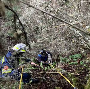 Photo courtesy Clallam County Fire District 3/ Firefighters rescue Sparky the dog on Dec. 23 from a steep hillside off Finn Hall Road.