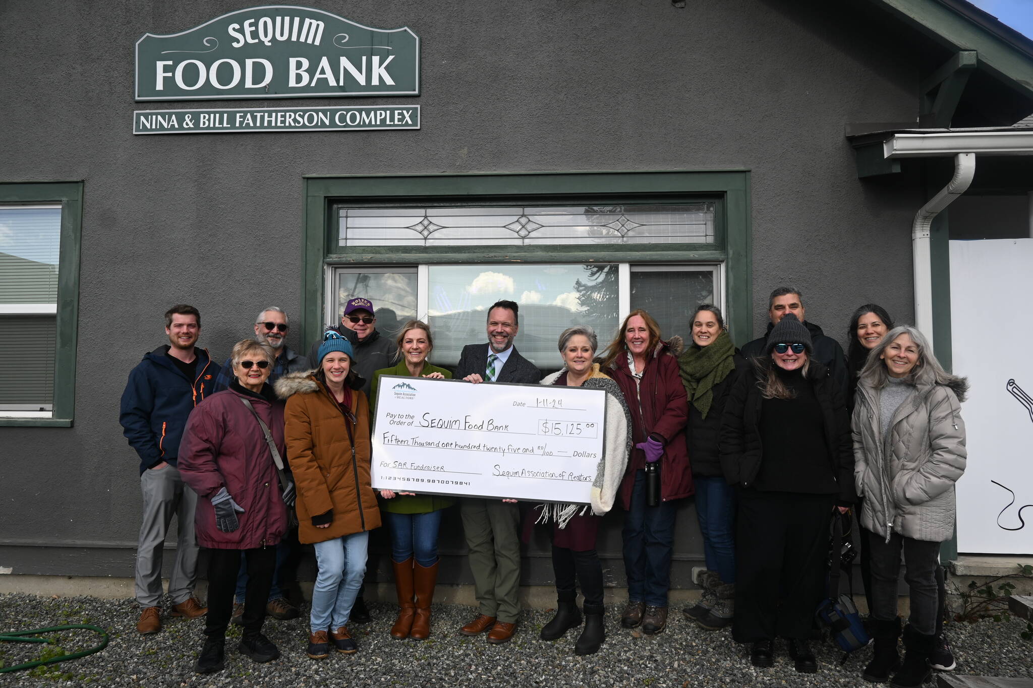 Sequim Gazette photo by Michael Dashiell / Locals in needs of food assistance got another boost from the Sequim Association of Realtors, who in January presented Sequim Food Bank representatives with a check for more than $15,000 collected during their annual Holiday Fundraiser. Presenting the funds in mid-January, are (back row, from left) Matt Holland, Tyler Conkle and Stu Marcy, (middle row, from left) Linda French, Lily Todd, Katie Marble, Nikki Stevenson, Craig Stevenson, Sequim Food Bank director Andra Smith, Marguerite Glover, Kaylene Byrne, Kelly O’Mera and FaLeana Wech, and (front row, from left) Julianne Campbell and Catherine Cote.
