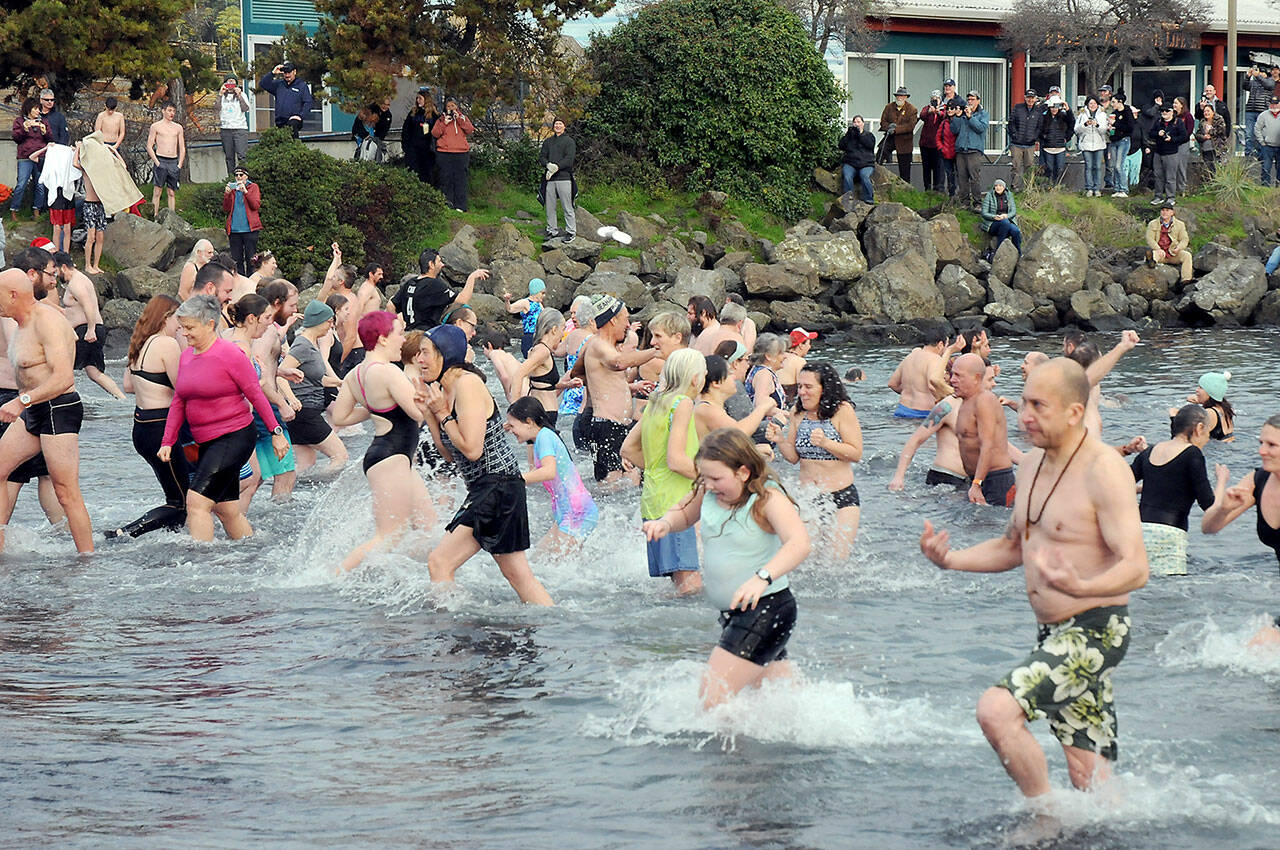 Photo by Keith Thorpe/Olympic Peninsula News Group / Participants in the New Year’s Day polar bear dip in Port Angeles run in and out of the chilly water of Port Angeles Harbor at Hollywood Beach as onlookers watch from the shore on Jan. 1.