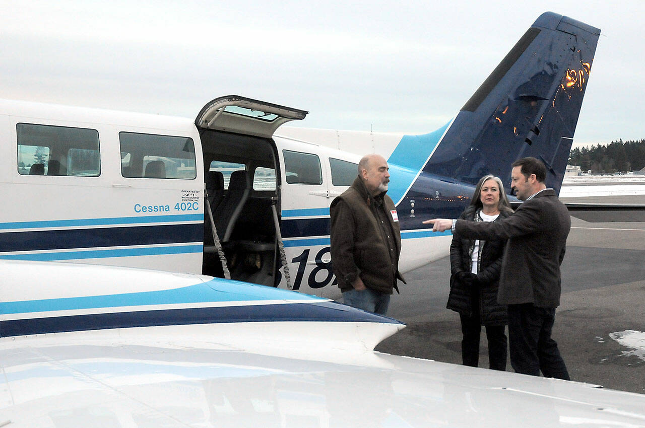 Photo by Keith Thorpe/Olympic Peninsula News Group
Clint Ostler, president of Dash Air Shuttle, right, points out features of the Cessna 402C aircraft to Peter Metz, left, and Kim Reynolds, both of Port Angeles, during an open house for the air service on Jan. 16 at William R. Fairchild International Airport in Port Angeles.