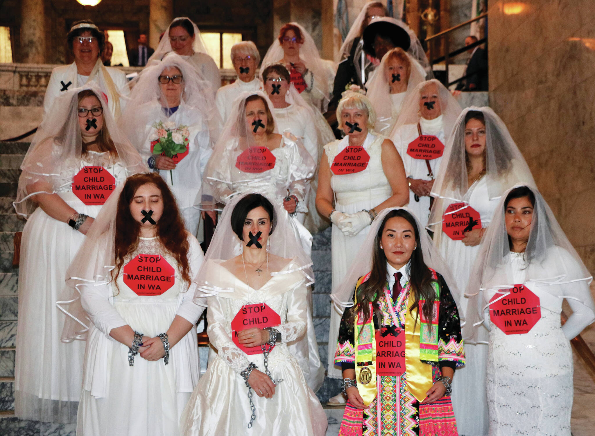 Photo by Aspen Anderson/Washington State Journal / Kate Yang (first row, second from right) protests child marriages in Olympia wearing a colorful wedding dress to honor her Hmong heritage.