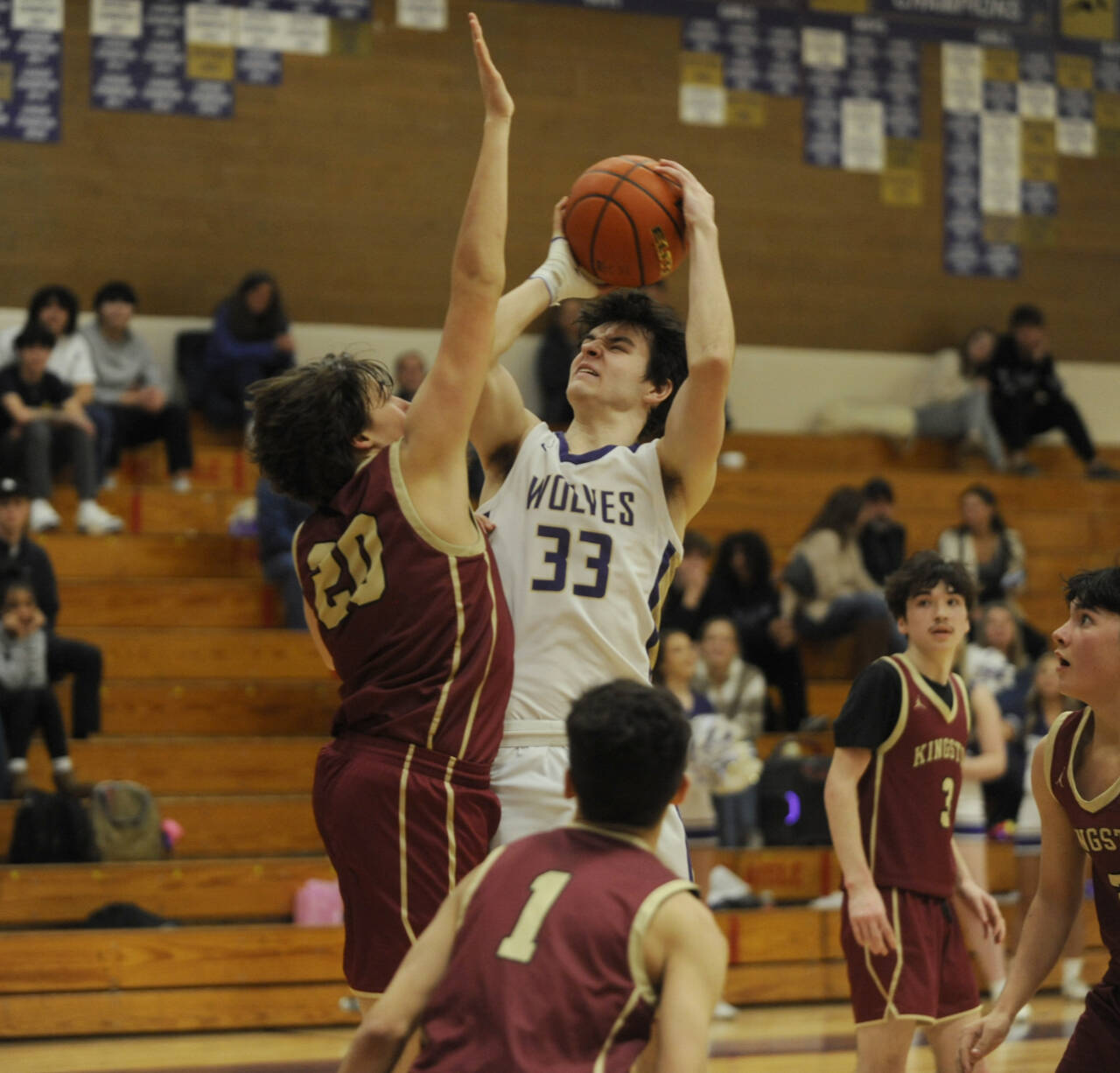 Sequim Gazette photo by Michael Dashiell / Sequim's Jamison Gray, center, takes a jumper over Kingston's Dae'veon Swan in the fourth quarter of a 63-50 SHS victory on Jan. 26.