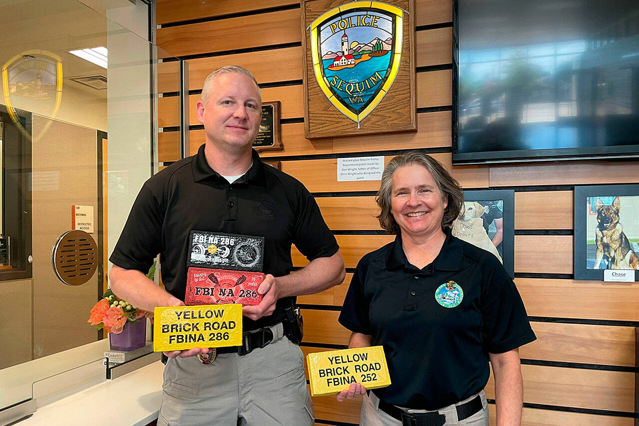 Sequim Gazette file photo by Matthew Nash/ Sequim deputy police chief Mike Hill will take over as chief for retiring police chief Sheri Crain on March 1. Here they stand together to show bricks they earned at the FBI National Academy with Hill graduating in 2023, and Crain in 2013.