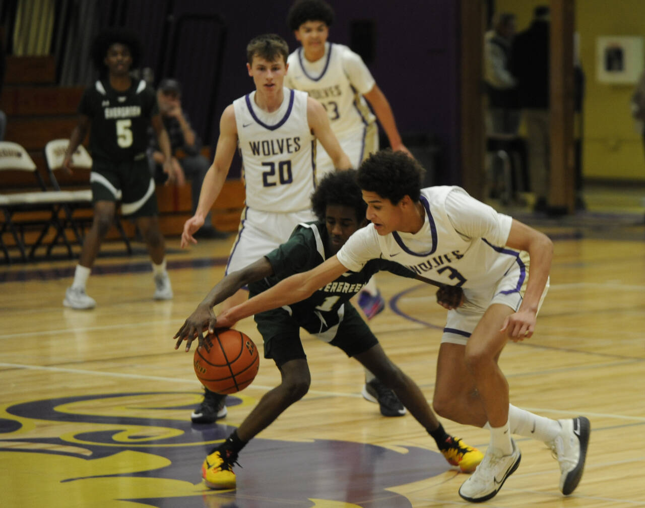 Sequim Gazette photo by Michael Dashiell / Sequim’s Solomon Sheppard, right, steals the ball from Evergreen’s Leebaan Sami in the first half of the Wolves’ 73-61 bi-district tournament win on Feb. 13. Looking on is Sequim’s Mason Rapelje (20) and Charlie Grider.