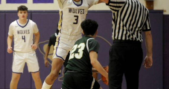 Sequim Gazette photo by Michael Dashiell
Sequim’s Solomon Sheppard, center, defends Evergreen’s Miguel Delgado in the first half of the Wolves’ 73-61 bi-district tournament win on Feb. 13. Looking on is Sequim’s Keenan Green.