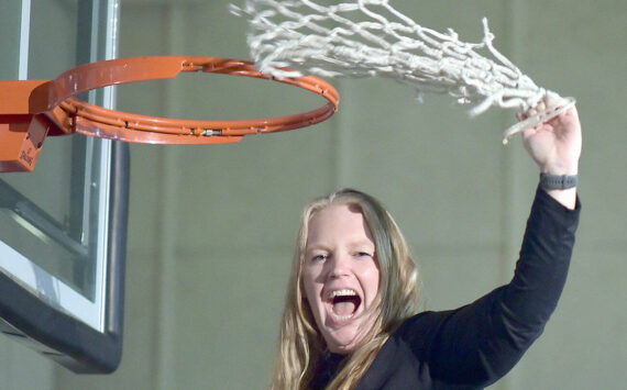 KEITH THORPE/PENINSULA DAILY NEWS
Peninsula Pirate head coach Ali Crumb swings a freshly-cut net on Saturday in jubilation for winning the NWAC North Division championship, sending her team to the playoffs. As icing on the cake, Peninsula beat Everett 86-51 earlier in the evening.
