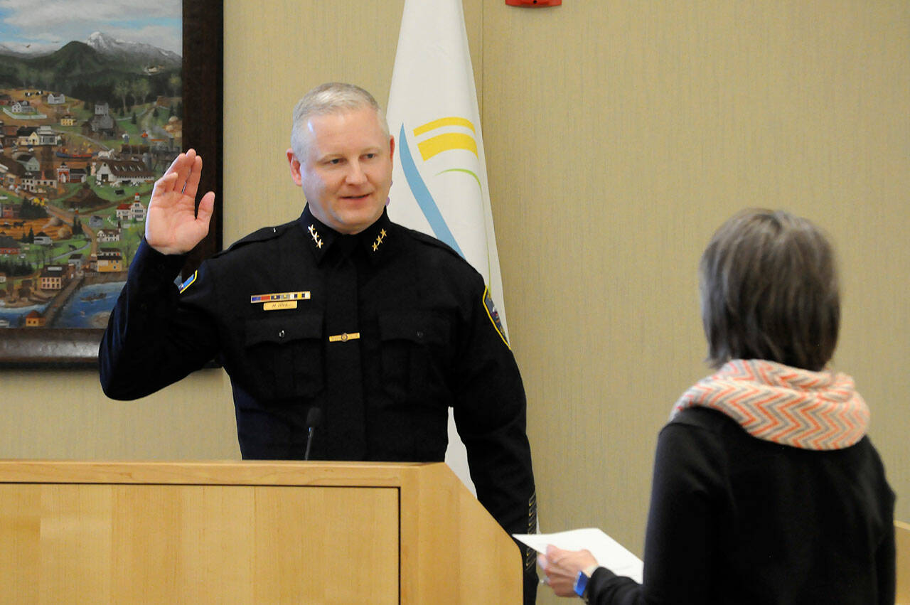 Sequim Gazette photo by Matthew Nash
Mike Hill takes his oath of office on March 1 from acting city clerk Heather Robley to become the City of Sequim’s new police chief.