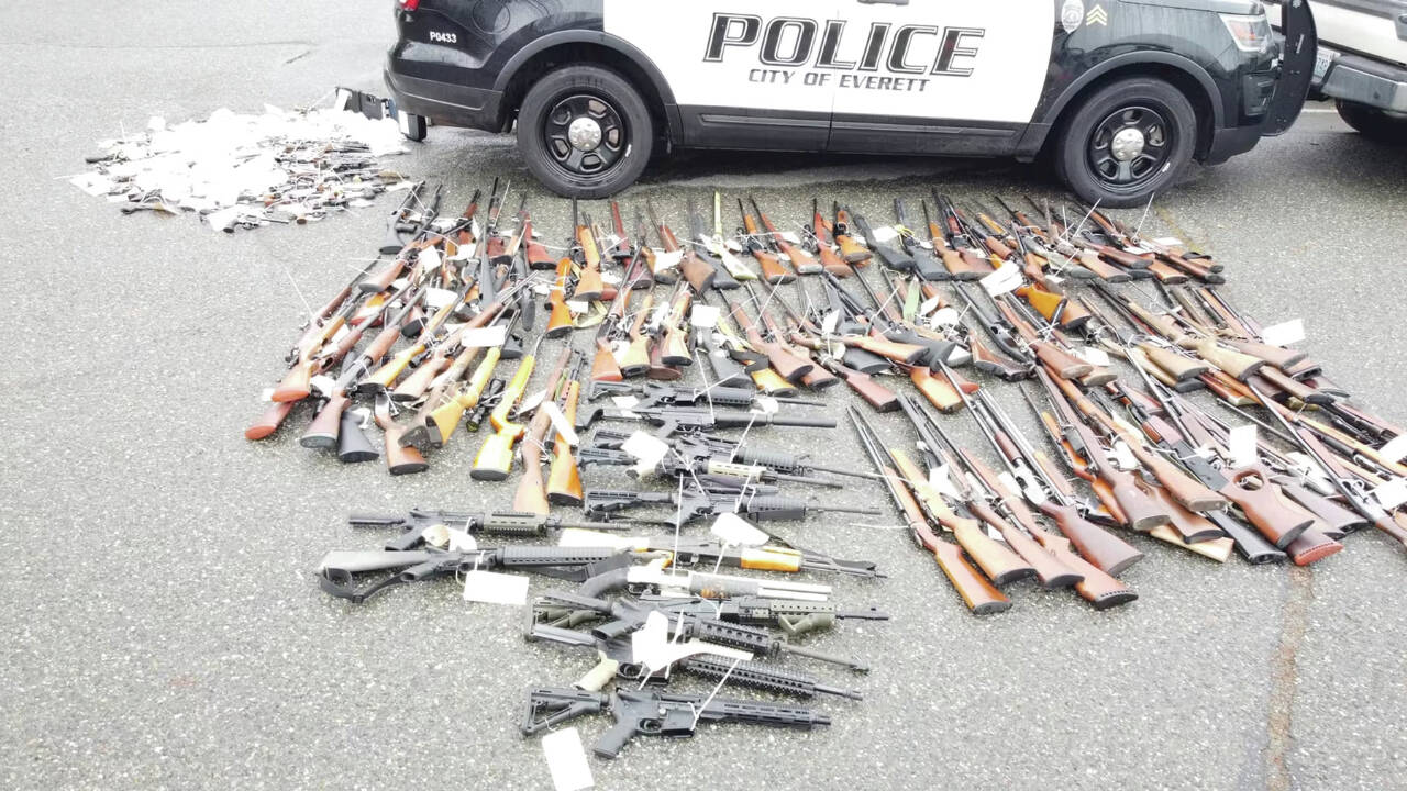 Photo courtesy of Everett Police Department / Returned lost or stolen firearms recovered by the Everett Police Department are laid out in a parking lot. The department started a program to get guns off the street called “guns for giftcards.”
