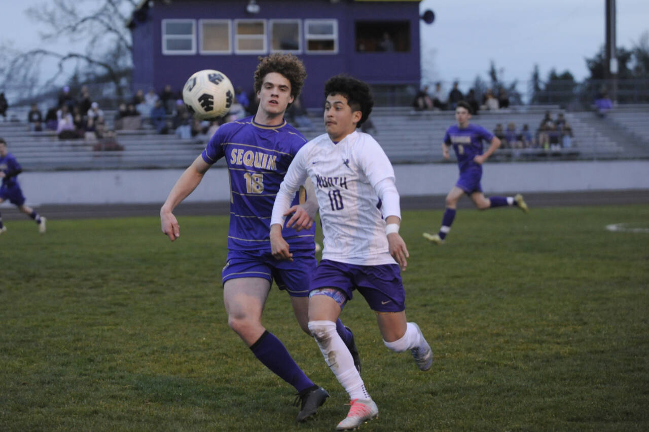 Sequim Gazette photo by Michael Dashiell / Sequim’s Sam Stewart, left, battles North Kitsap’s Pepe Deluna for possession in the Wolves’ 4-0 home loss to NK’s Vikings on March 21.