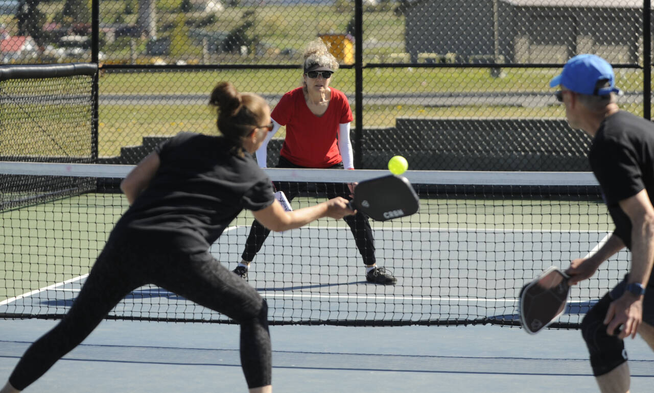 Sequim Gazette photo by Michael Dashiell / Patricia Knapp, center, of the X-40 Kraken looks to get a shot past Jennifer Cox and Tim Scott of the Lavender Lobbers in a Sequim Picklers Minor League Pickleball match last week.