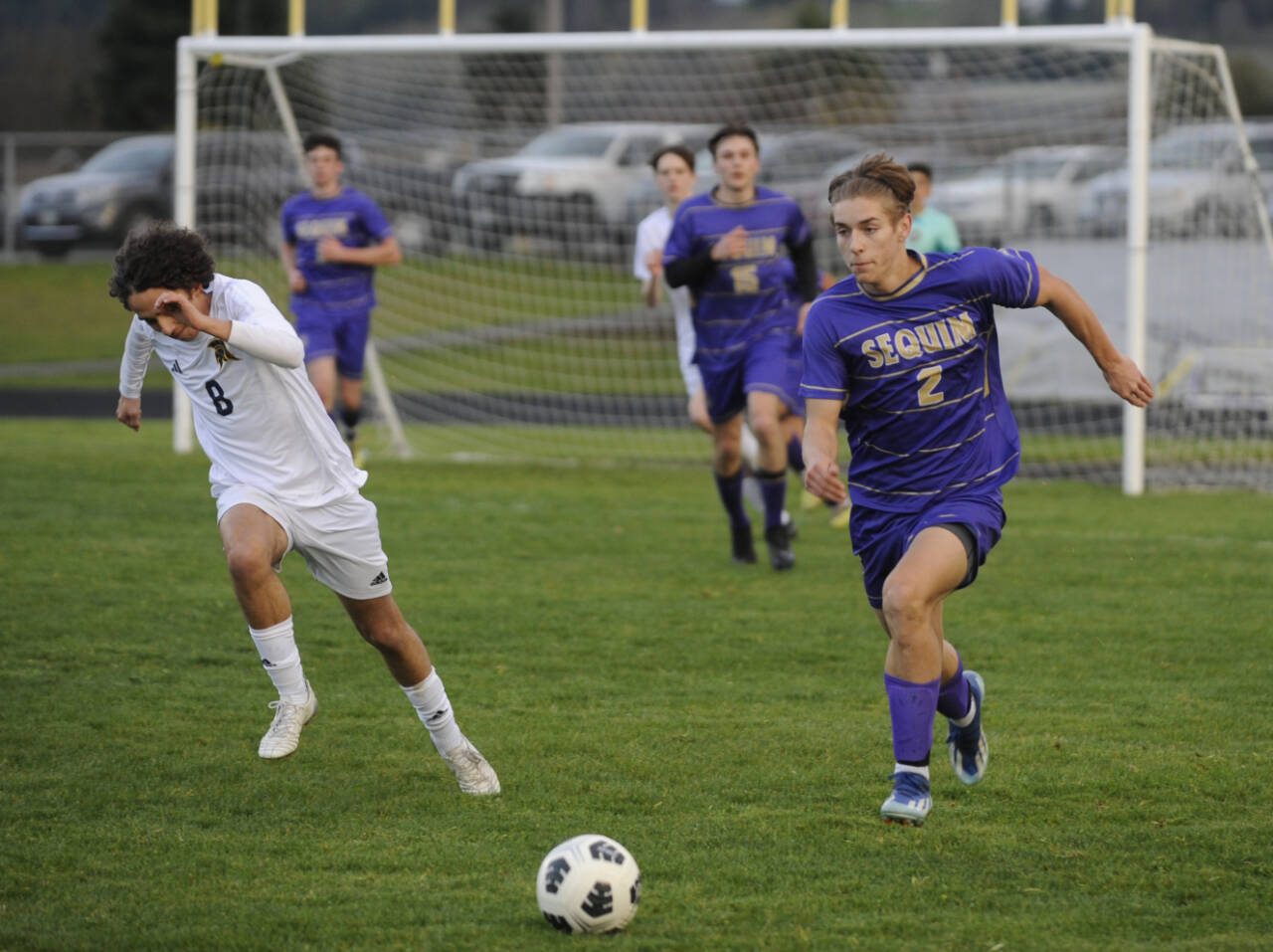 Sequim Gazette photo by Michael Dashiell / Sequim’s Preston Kurtze, right, dribbles downfield and looks for a teammate in the Wolves’ 3-2 loss against Bainbridge on March 26.