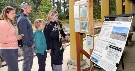 Members of the Bagley family of Forsyth, Ill., from left, parents Jessica and Cameron Bagley, and children Cody, 10, Addie, 12, and C.J., 7, look at an information kiosk on the Olympic National Park wildfires on Tuesday in front of the park visitor center in Port Angeles. (Keith Thorpe/Peninsula Daily News)