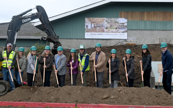Staff from the North Olympic Library System (NOLS) join project partners at the groundbreaking of the Sequim Library expansion on Wednesday. Pictured, from left, are Kyle and Carrie Priest, owners of Hoch Construction; NOLS board members Jennifer Pelikan; Cyndi Ross and chair Mark Urnes; NOLS collection services manager Erin Shield, facilities manager Brian Phillips, executive director Noah Glaude and Sequim Library manager Emily Sly; Marlo Dowell of Acila Consulting; and Pia Westen and Adam Hutschreider of SHKS Architects. (Michael Dashiell/Olympic Peninsula News Group)