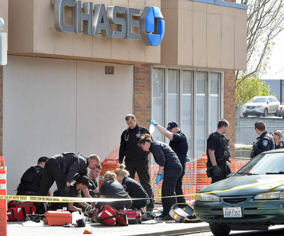 Police and rescue workers surround the scene of a disturbance on Friday morning at Chase Bank at Front and Laurel streets in downtown Port Angeles that resulted in a fatal shooting and the closure of much of the downtown area. (Keith Thorpe/Peninsula Daily News)