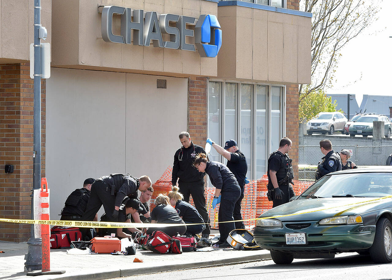 Photo by Keith Thorpe/Olympic Peninsula News Group
Police and rescue workers surround the scene of a disturbance at Chase Bank at Front and Laurel streets in downtown Port Angeles on May 3 that resulted in a fatal shooting and the closure of much of the downtown area.