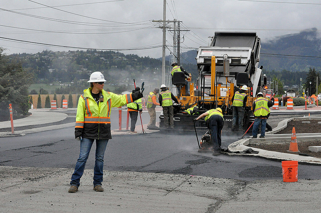 Sequim Gazette photo by Matthew Nash/ Sarah Bradley, a traffic control supervisor with Laborers’ Local 252, stops vehicles in Rock Plaza as paving work continues on the Sequim Avenue/Sequim-Dungeness Way roundabout on May 6.