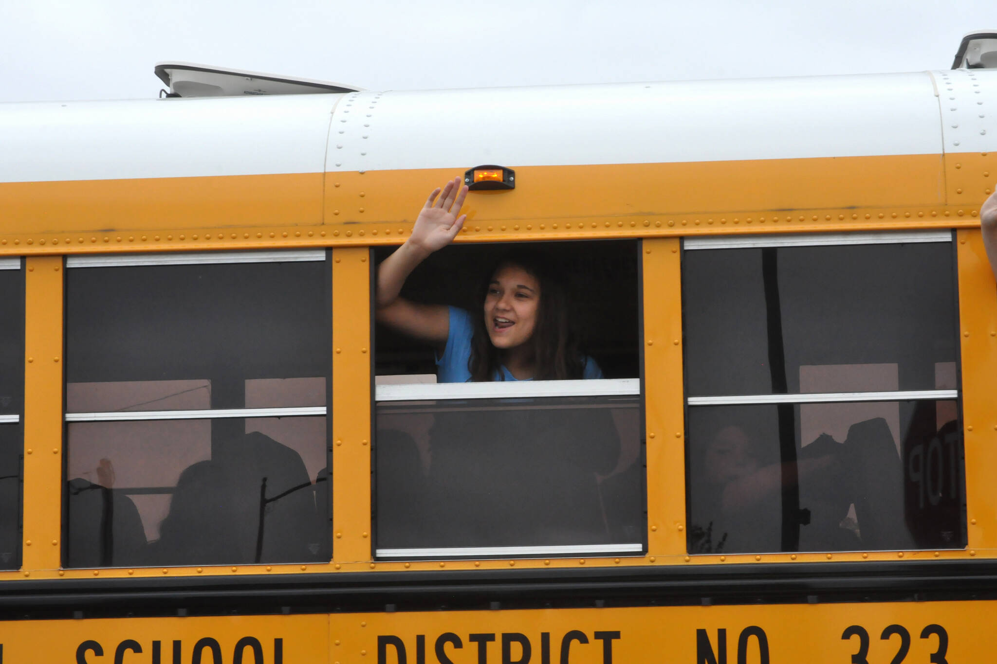 Sequim Gazette photo by Matthew Nash
Fifth grader Sky Steele waves to teachers and staff from her bus on June 12, the last day of school.