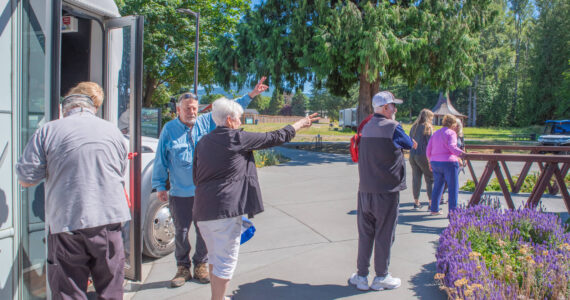 Sequim Gazette photo by Emily Matthiessen
Local resident and tour guide Bob Steelquist provides directions to American Cruise Lines passengers after they arrive by van at the Dungeness River Nature Center in Sequim.