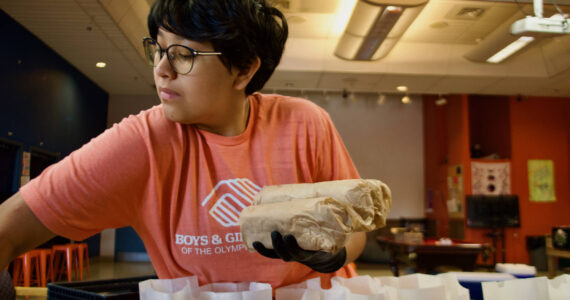 Arrow Edgecomb fills lunch sacks with Italian subs.