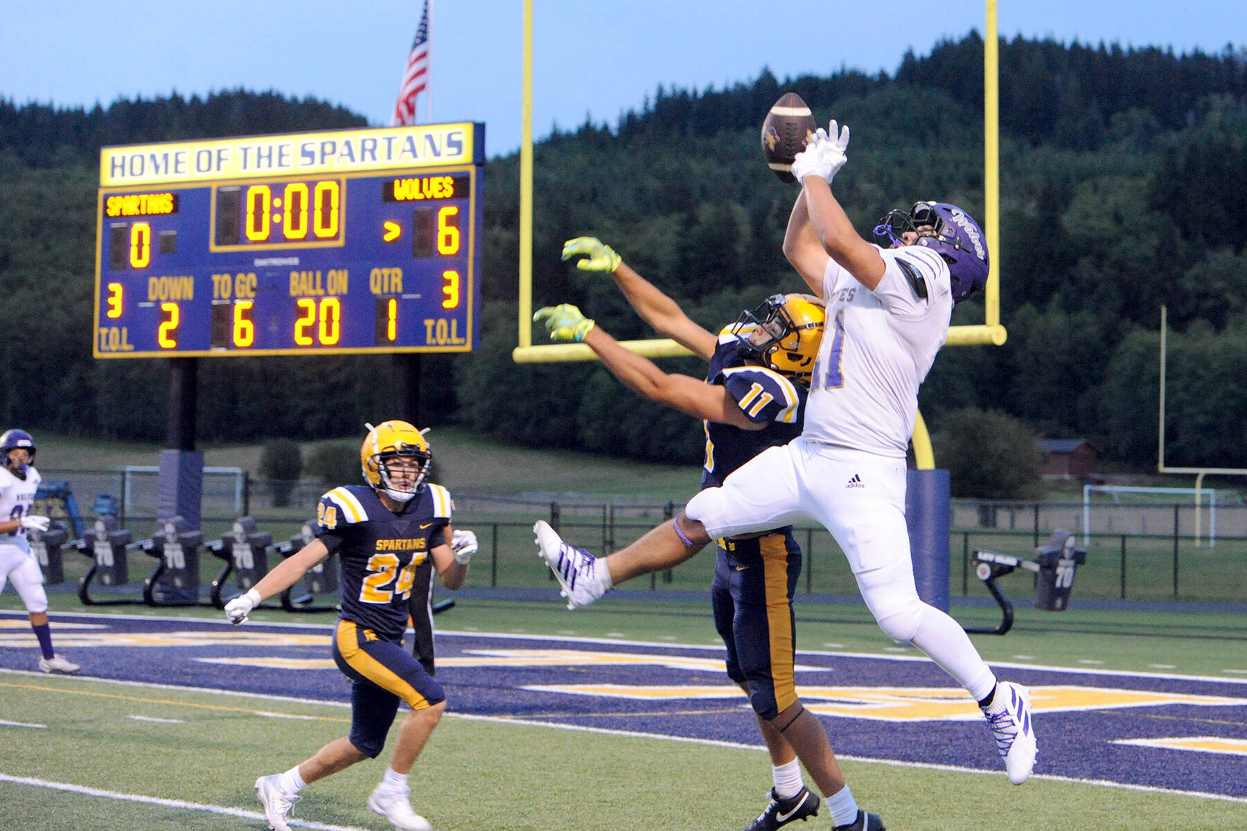 Photo by Lonnie Archibald for the Olympic Peninsula News Group
After this Sequim pass to Liam Wiker (11) on Friday, Sept. 5, it was deflected by Forks’ Cash Barajas (11) then intercepted by Spartan Kingston Steffen (24). The Wolves held on in the closing moments for an 18 to 14 win on the Spartan Turf.