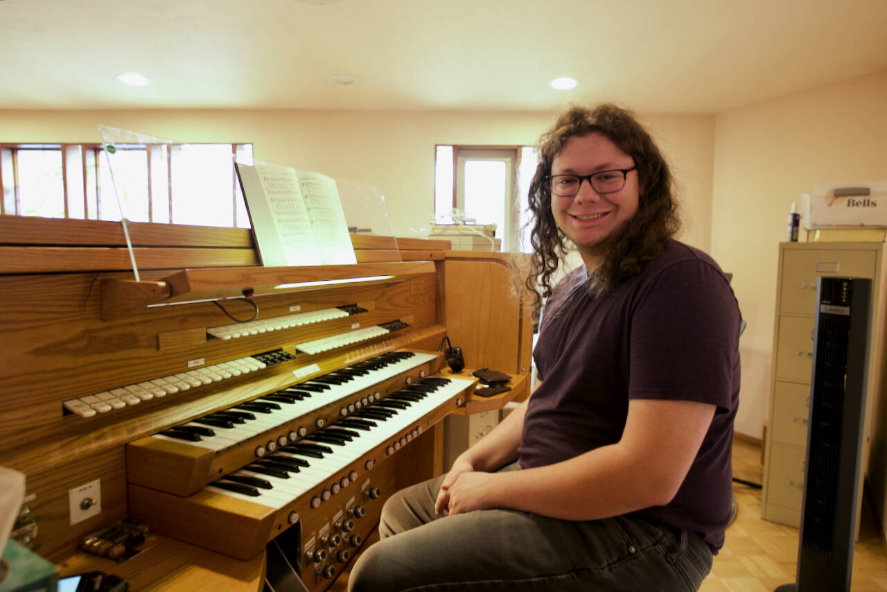 Edinger sits at the organ he now commands at Faith Lutheran Church in Sequim. There are 10 ranks of pipes, each with 61 notes, including flats and sharps.