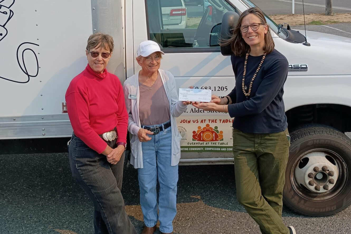 Jen Colmore, right, community engagement coordinator for Sequim Food Bank, accepts a donation of $2,150 from Soroptimist International of Sequim. The check was presented by Natasha Merkkuloff-Nichols, left, the organization’s president-elect, and Sandy Lawrence, its treasurer.